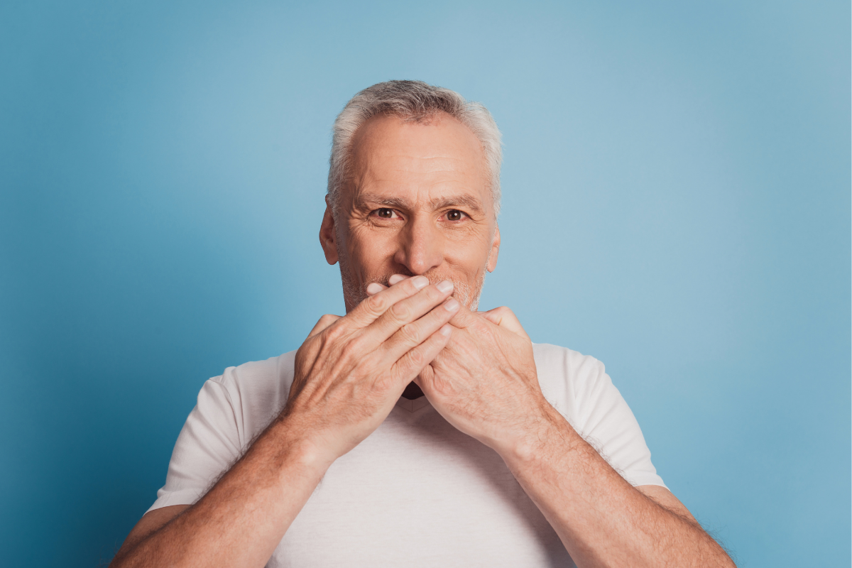 Elder man covers his mouth with his hands