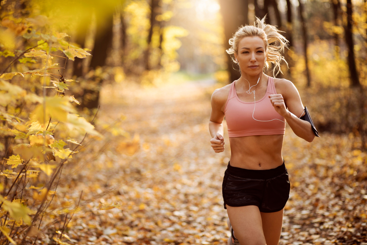 woman athlete runs in autumn forest