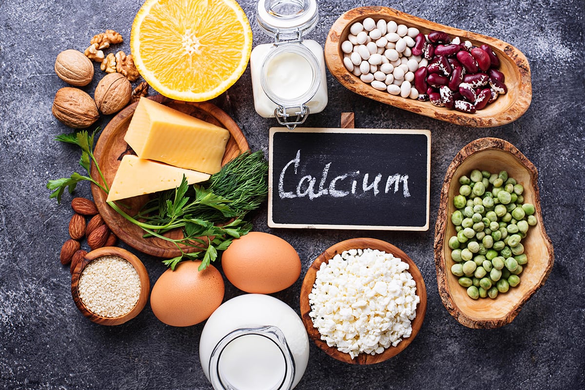 τροφές με ασβέστιο γύρω από μαυροπίνακα με τη λέξη calcium