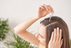 woman puts castor oil on hair