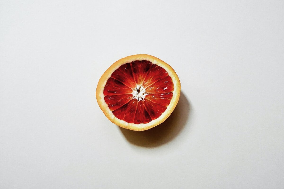 Slice of blood orange in a white background.