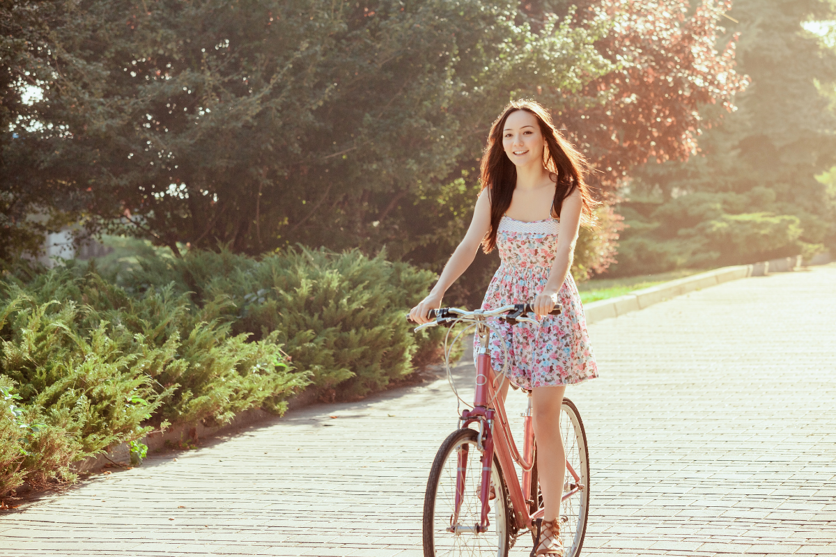 Νεαρή γυναίκα κάνει ποδήλατο στη φύση.