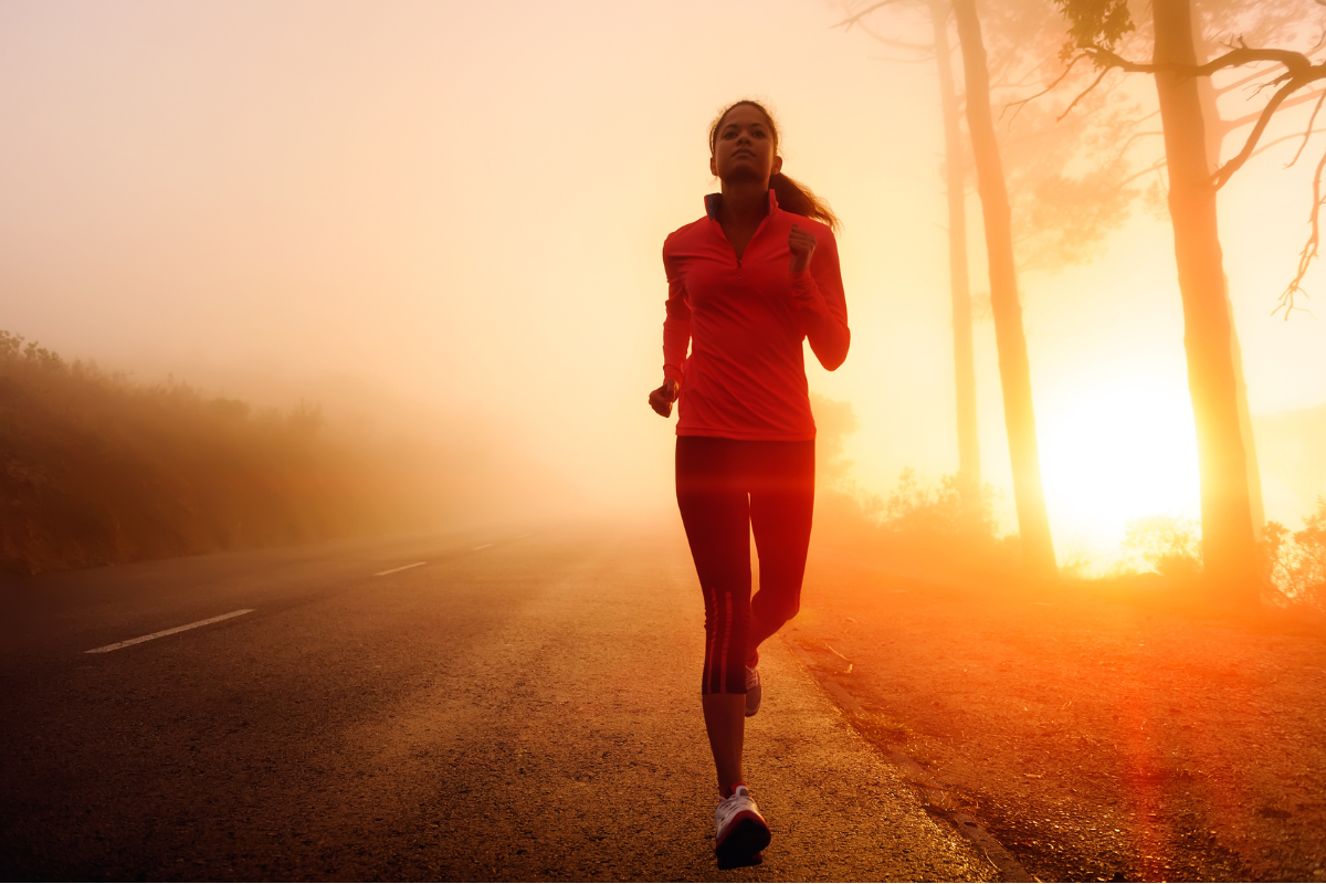 woman runs in the dawn wearing athletic clothes