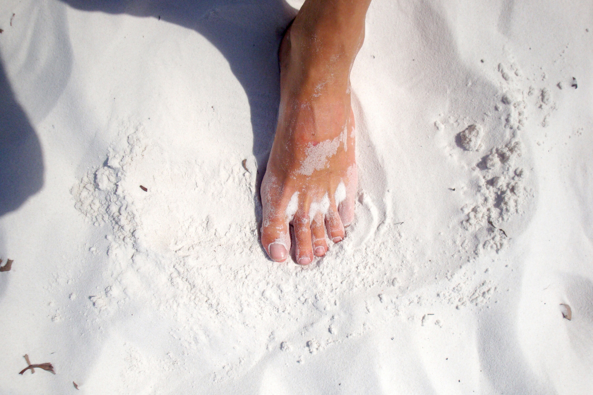 πόδι που πατάει σε λευκή άμμο
