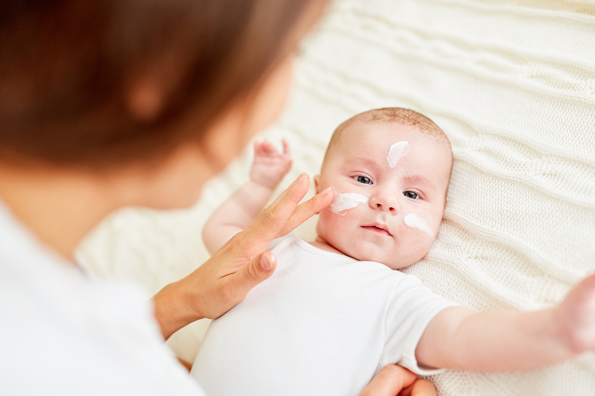 mum puts cream on baby's face