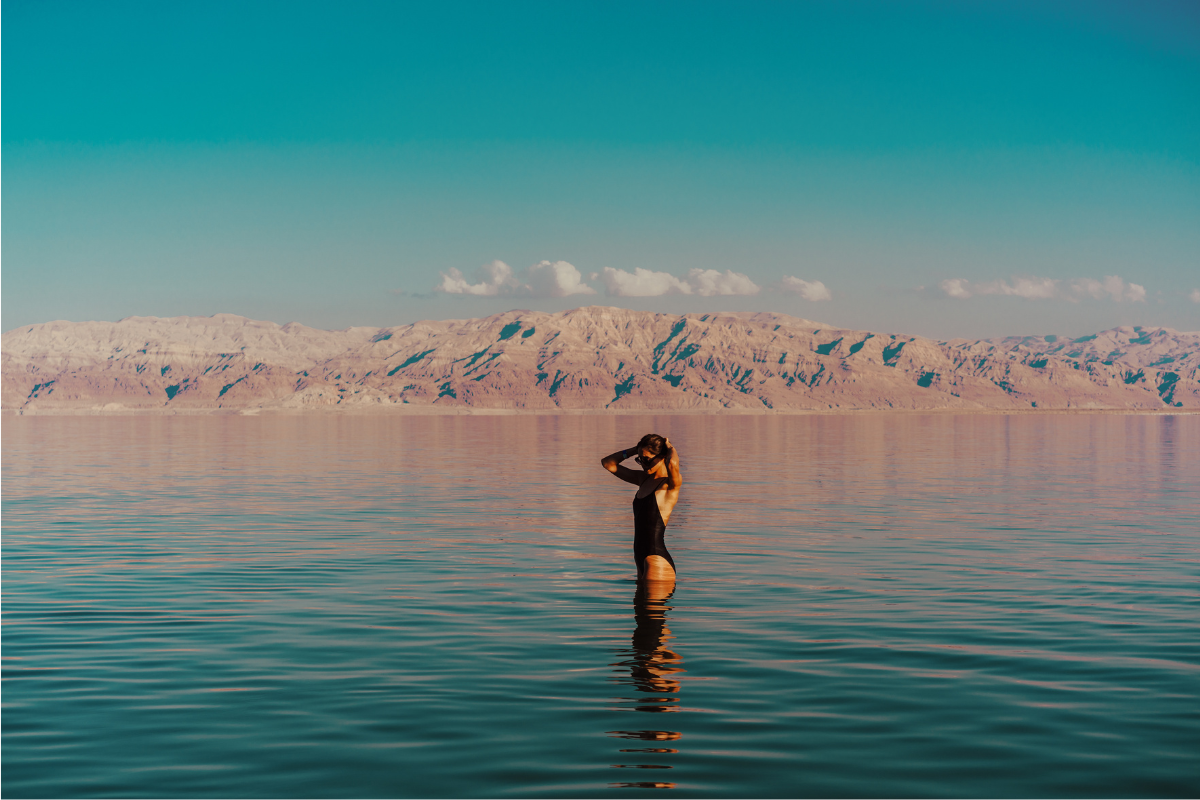γυναίκα με μαύρο μαγιό στέκεται όρθια στη Νεκρά Θάλασσα
