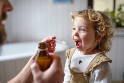 blond child opens mouth to get syrup