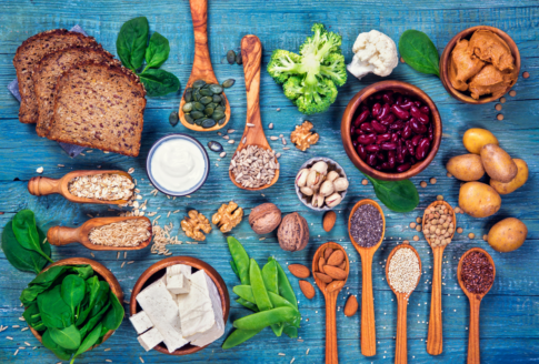 τροφές πλούσιες σε φυτική πρωτεΐνη σε ξύλινες κουτάλες & πάνω σε μπλε ξύλο