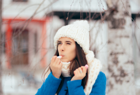 γυναίκα βάζει lip balm σε χειμωνιάτικο σκηνικό