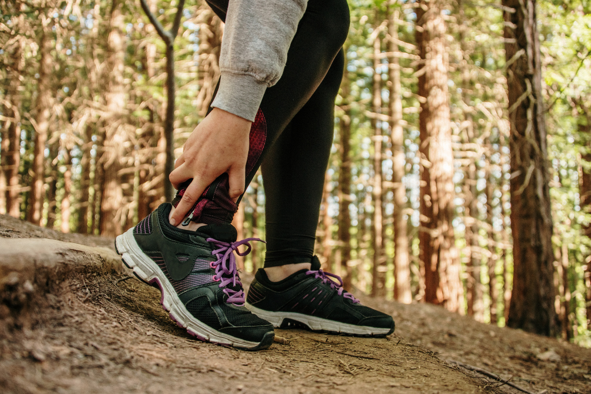 womans feet in sports shoes in the forest