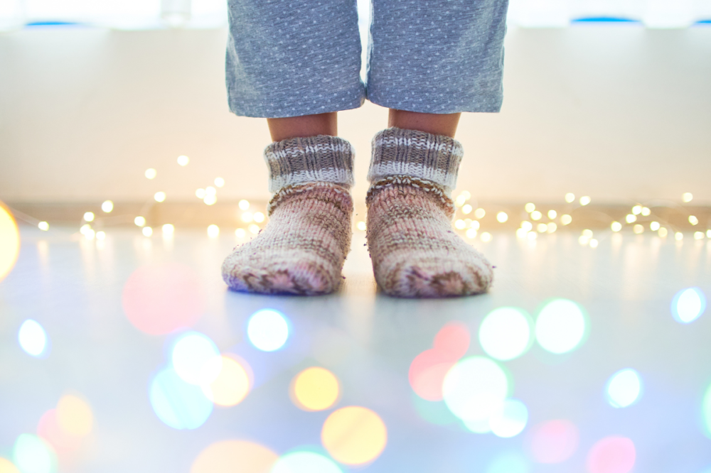 πόδια με μάλλινες κάλτσες πάνω σε ιριδίζον πάτωμα
