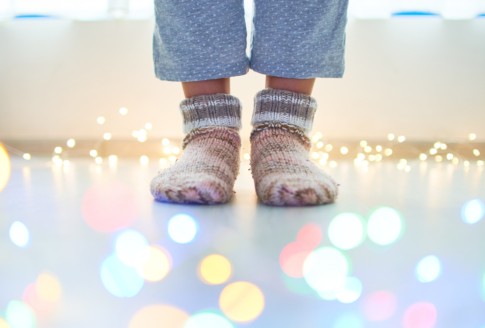 πόδια με μάλλινες κάλτσες πάνω σε ιριδίζον πάτωμα