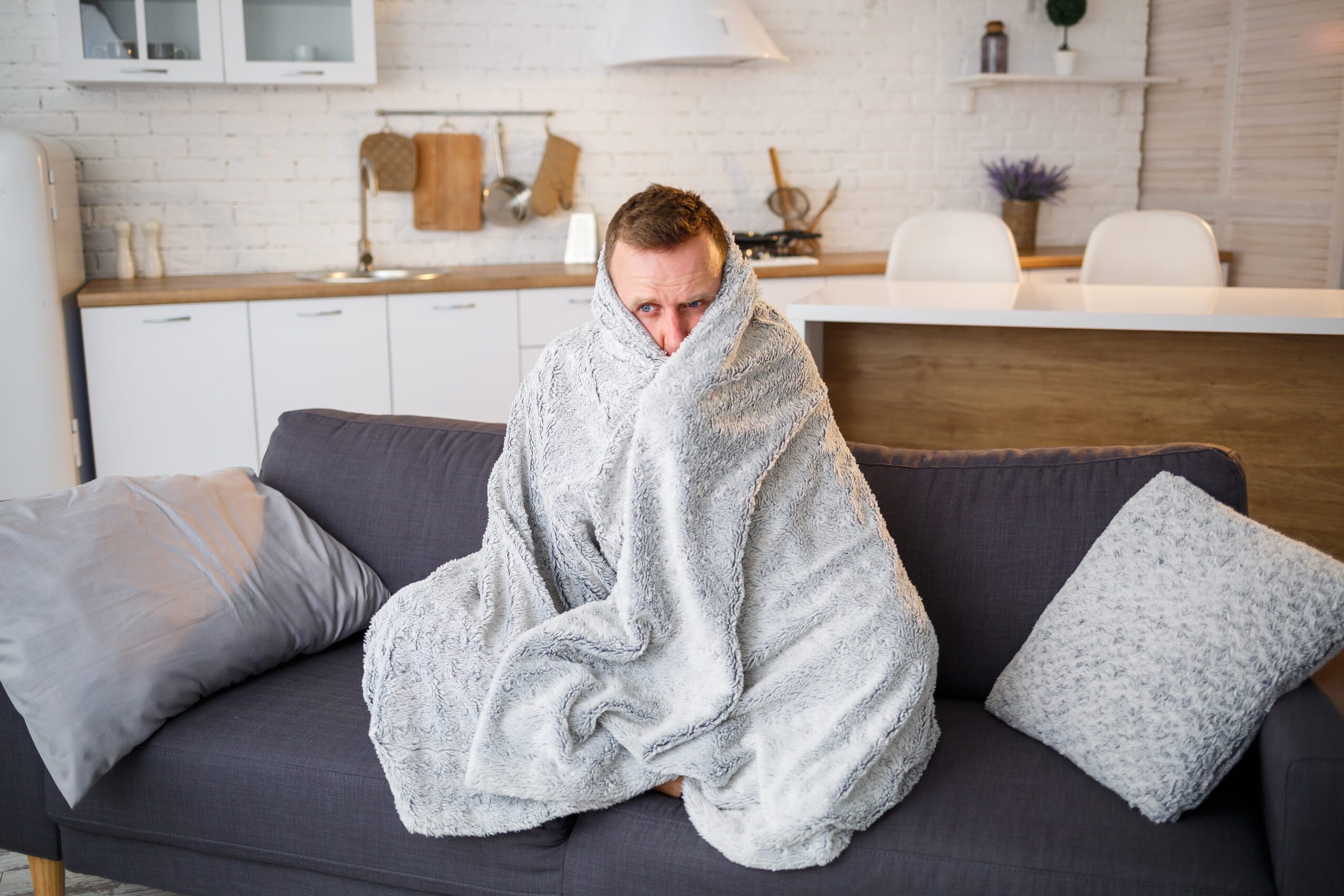 άρρωστος άντρας με υποθερμία καλλυμένος με κουβέρτα