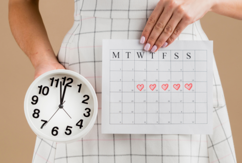 γυναίκα κρατά ρολόι & ημερολόγιο περιόδου