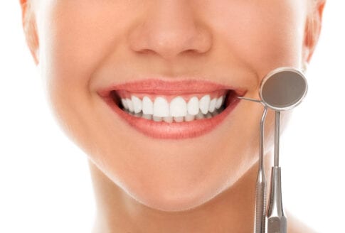 γυναίκα δείχνει τα λευκά δόντια της χωρίς ουλίτιδα