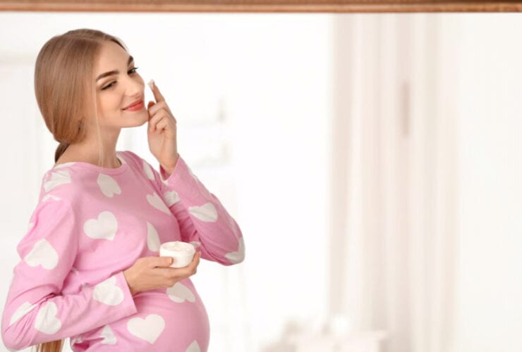 έγκυος γυναίκα δοκιμάζει κρέμα προσώπου