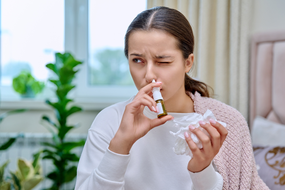 woman with sinusitis uses spray for nasal congestion